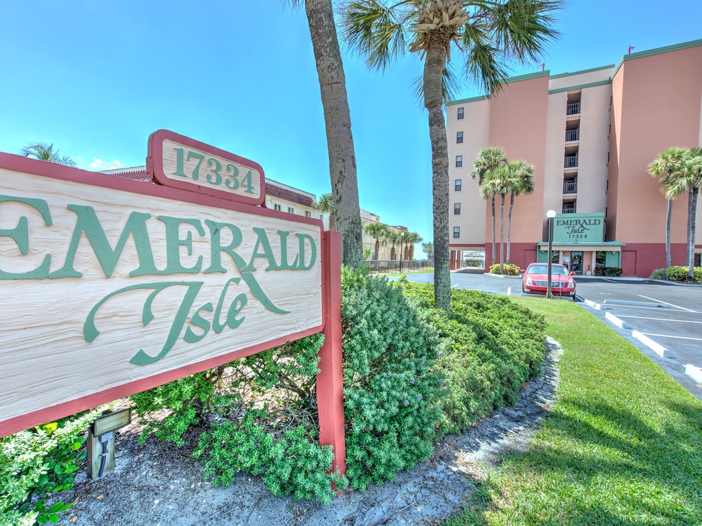 Emerald Isle property entrance welcomes guests with tropical landscaping and convenient parking.
