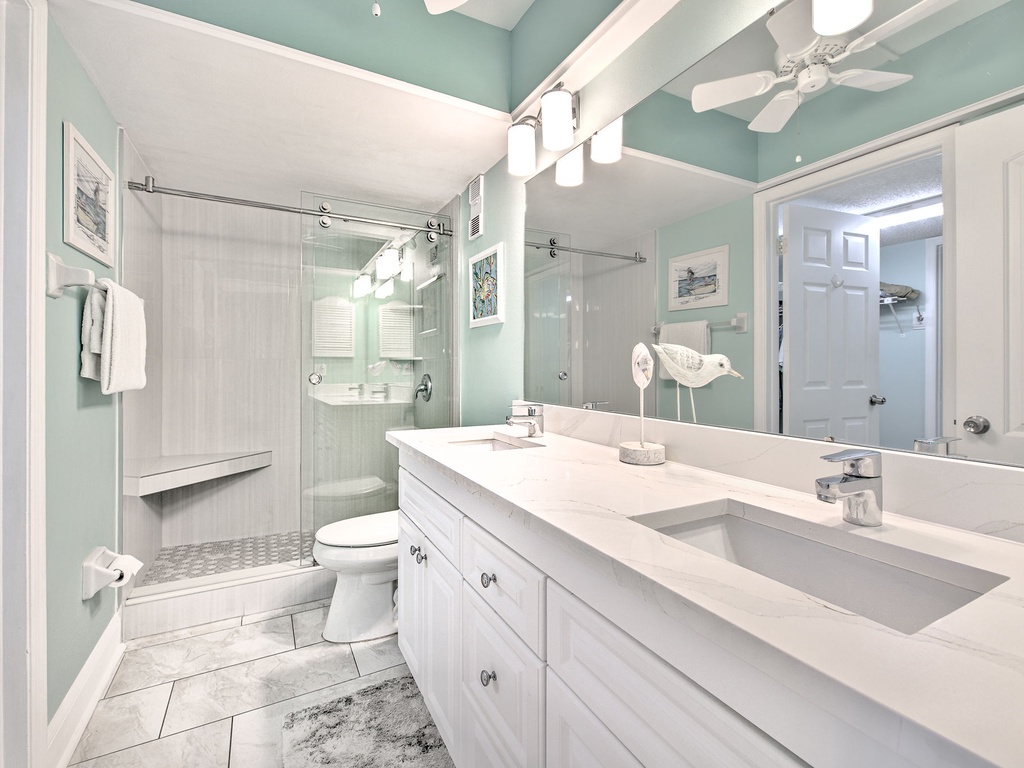 Step into your serene spa-like bathroom with calming coastal colors, elegant quartz counters, and a spacious glass shower for refreshing mornings.
