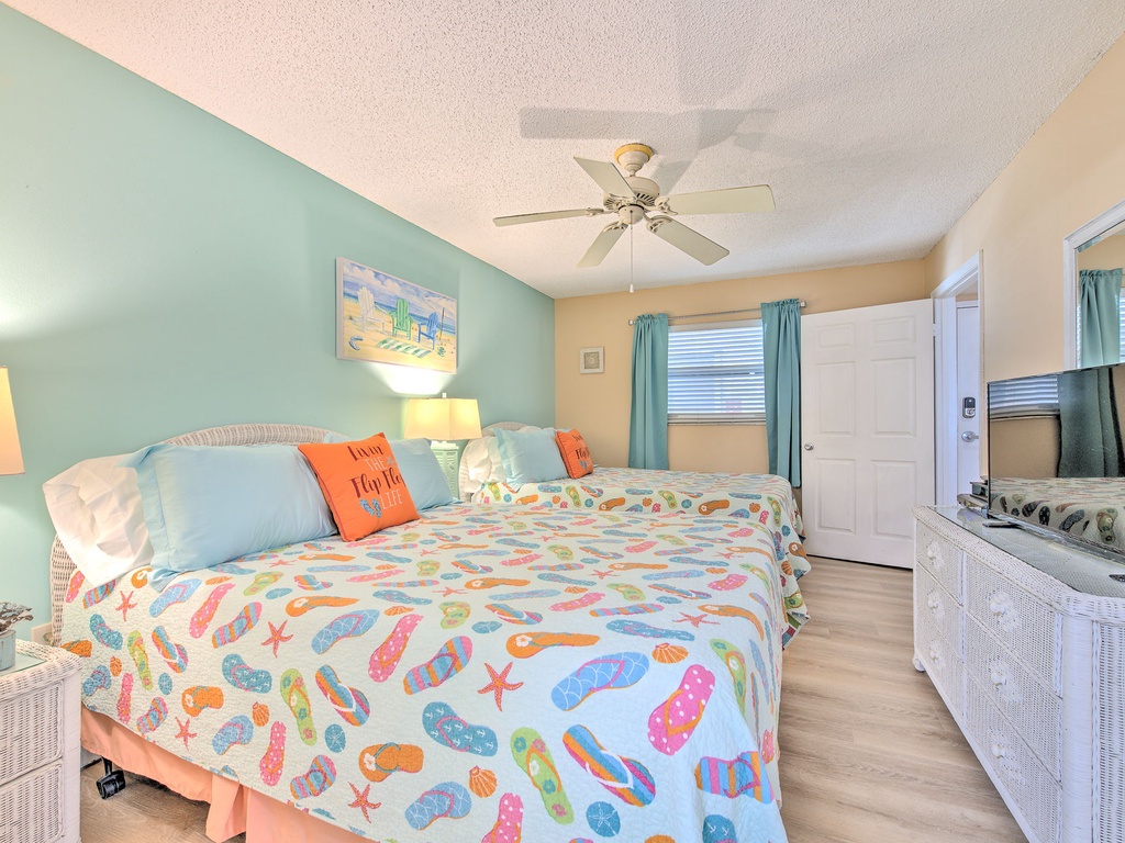 Step into your bright coastal bedroom featuring cheerful flip-flop linens and tropical colors that instantly make you smile.