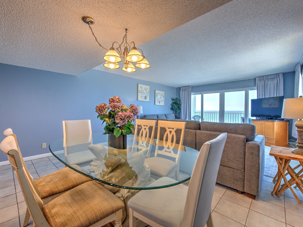 Your elegant dining space features a glass table for memorable meals with ocean views through panoramic windows.
