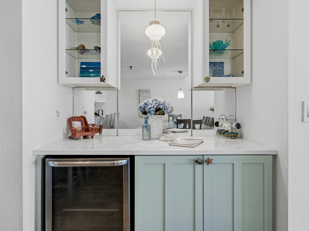 Your coastal-themed wet bar area features elegant marble countertops and charming sea-inspired décor, perfect for entertaining.