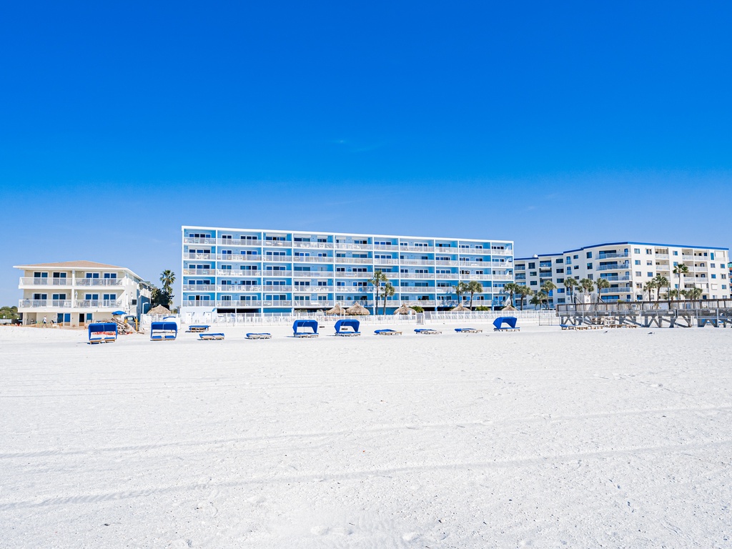 Beachfront property offers direct access to pristine white sand and crystal-clear waters under endless blue skies.