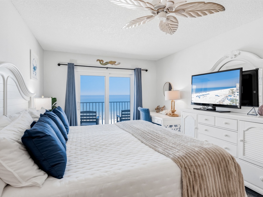 Wake up to stunning ocean views from your private balcony, while coastal breezes from the ceiling fan keep you comfortable in this serene beachfront bedroom.