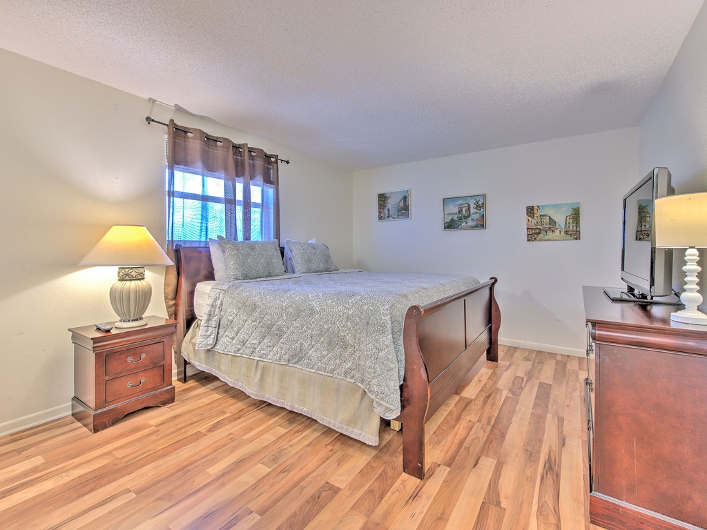 Relax in your peaceful bedroom featuring warm wood furnishings, soft lighting, and charming artwork creating the perfect retreat for restful nights.