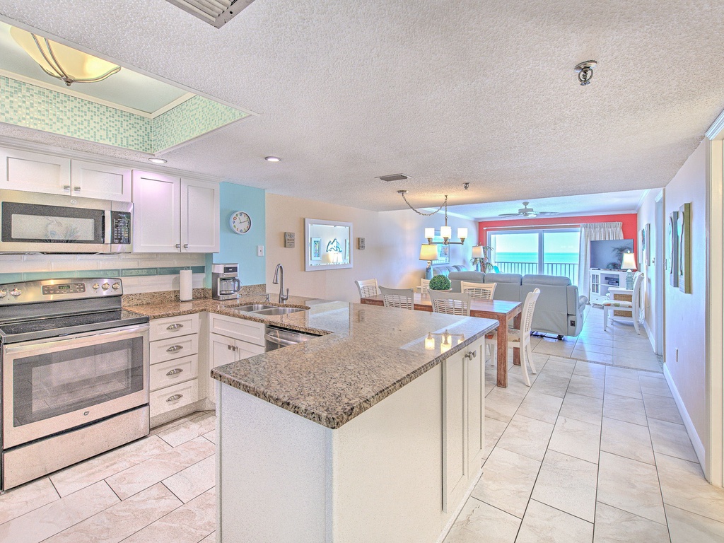 Your fully equipped kitchen features granite countertops, modern appliances, and flows seamlessly into the bright dining area with stunning ocean views.