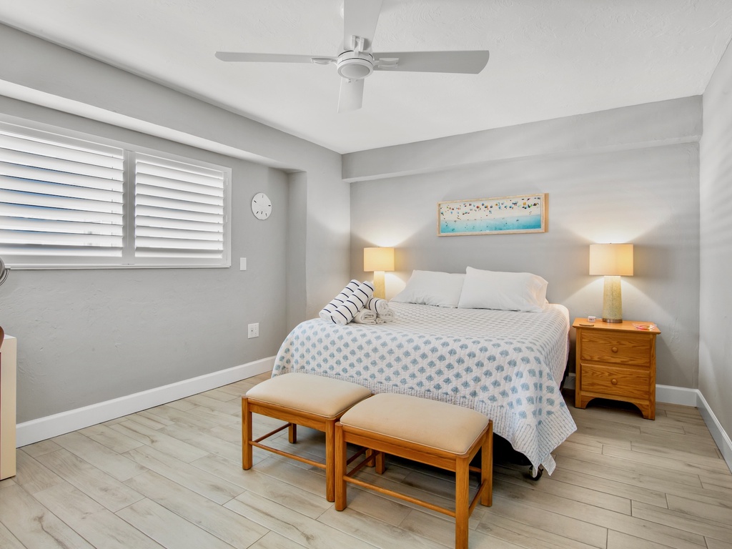 Drift off to sleep in your serene bedroom with coastal touches, warm bedside lighting, and gentle ceiling fan keeping you comfortable.