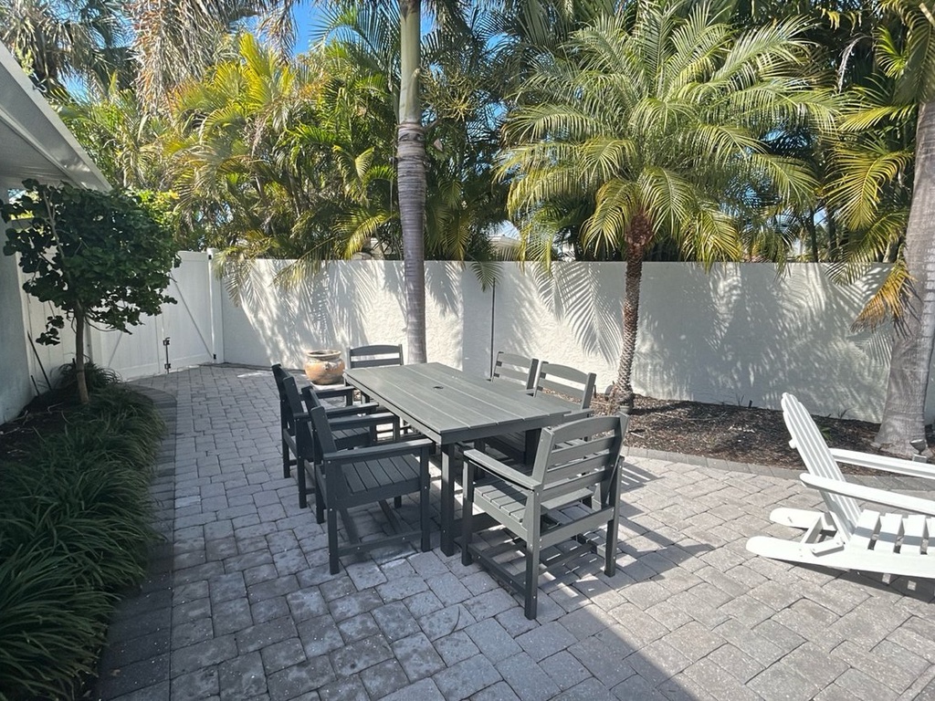 Your private outdoor oasis features tropical palms, spacious dining for six, and cozy lounge chairs—perfect for morning coffee or evening gatherings.