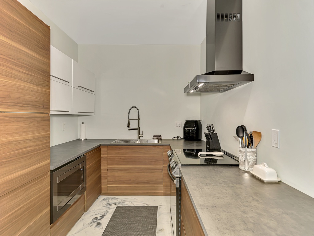 Step into your sleek modern kitchen with warm wood finishes, stainless steel appliances, and everything you need to create memorable meals.