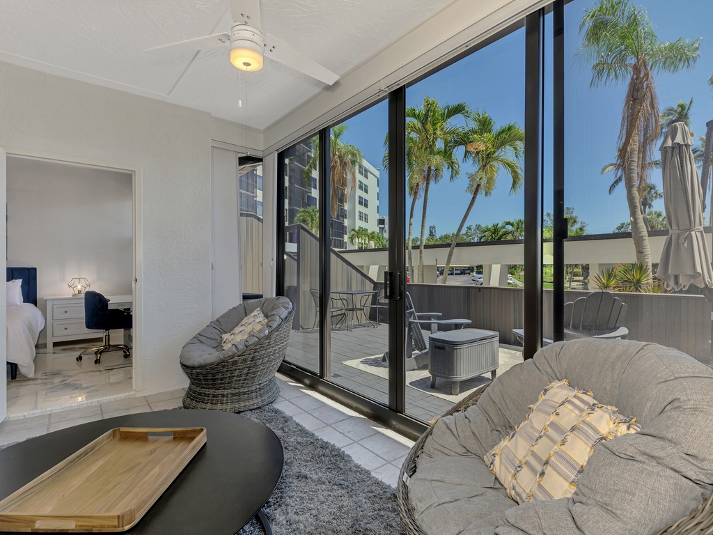 Relax in your modern living space with floor-to-ceiling windows opening to your private balcony with hot tub and tropical palm tree views.
