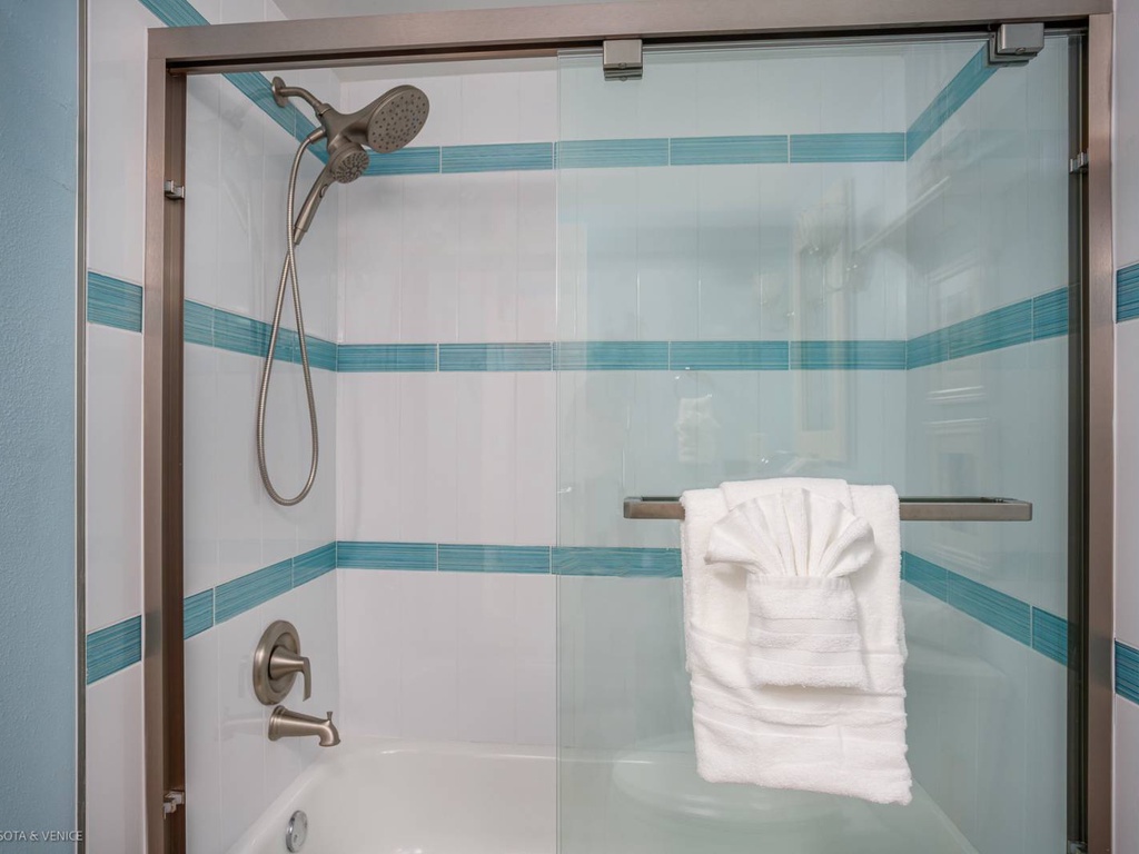 Step into your private spa-like shower with gleaming tiles and fresh towels awaiting your refreshing escape.