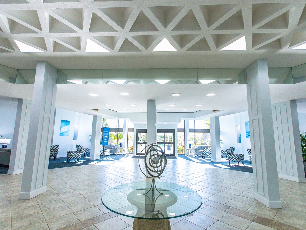 Step into an elegant lobby with striking geometric ceiling details, modern art, and comfortable seating areas that welcome you home.