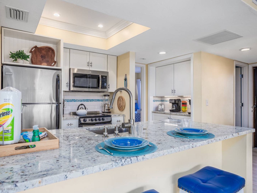 Step into your fully equipped kitchen with granite counters, stainless appliances, and thoughtful coastal touches that make cooking a joy.
