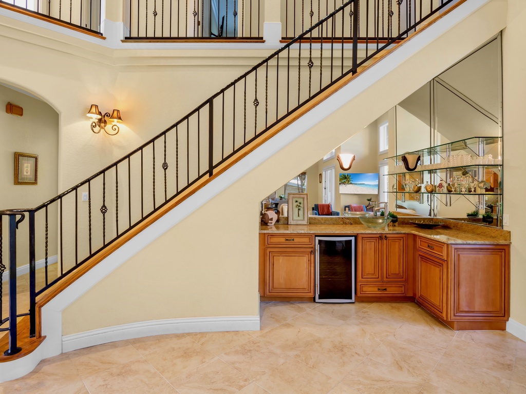 Elegant wet bar beneath the grand staircase