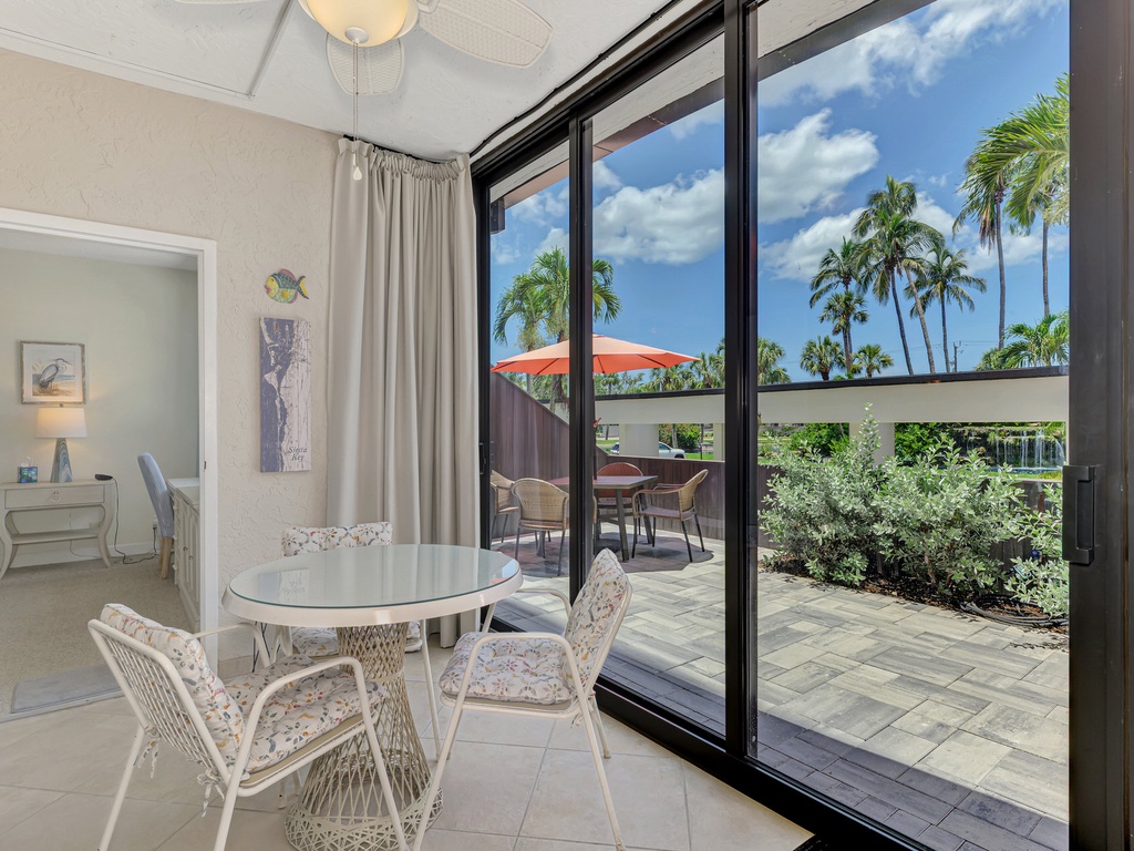 Your bright dining area flows seamlessly to your private patio, where swaying palms frame tropical views beyond.