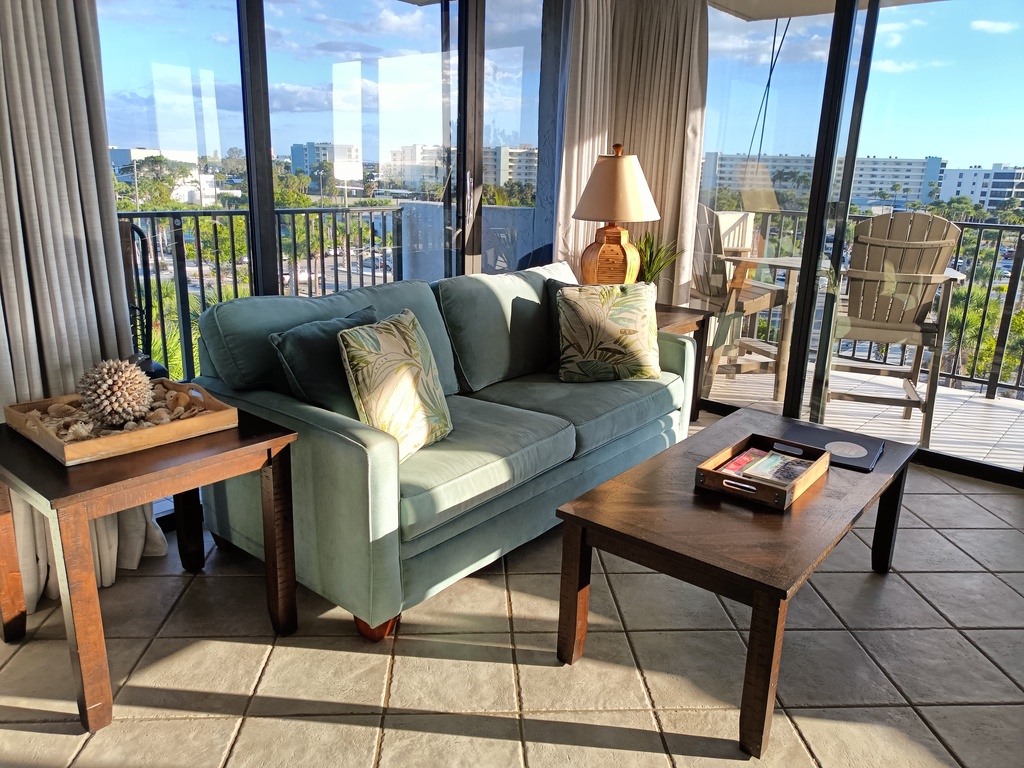 Sink into your cozy living room where floor-to-ceiling windows frame stunning city views and natural light bathes the space in warmth.