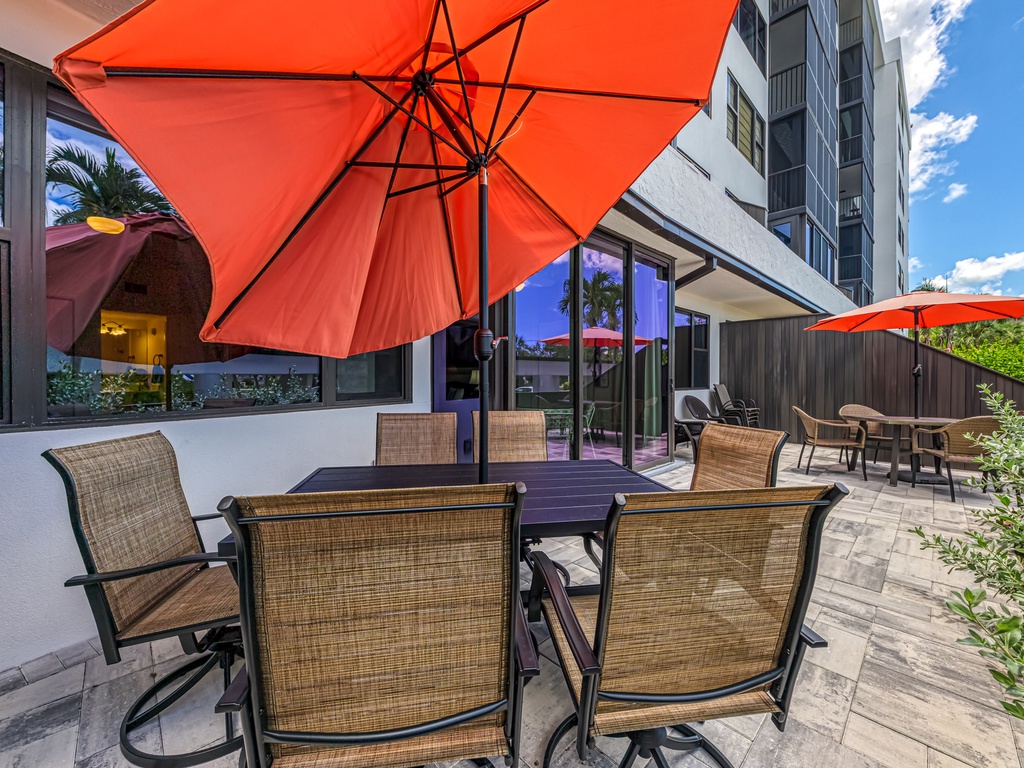 Enjoy al fresco dining on your private patio with comfortable seating and vibrant umbrellas for perfect shade.