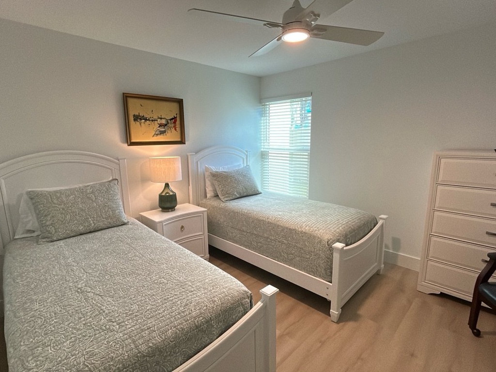 Rest peacefully in your comfortable twin bedroom with ceiling fan, storage, and natural light streaming through the window.