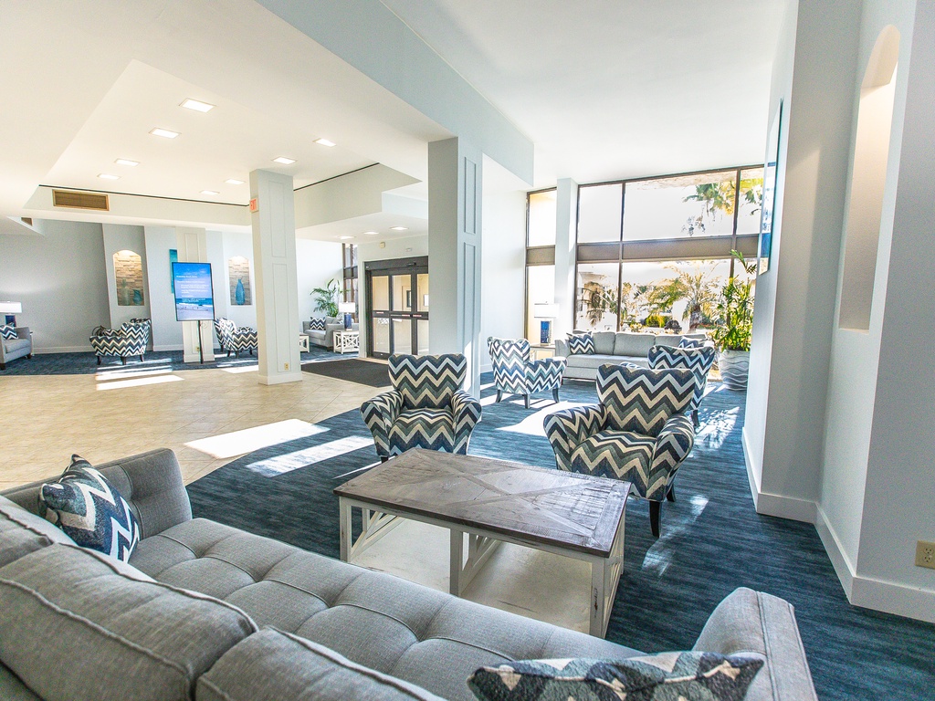 Unwind in this bright, modern lobby where stylish chevron chairs and plush seating create your perfect relaxation spot.