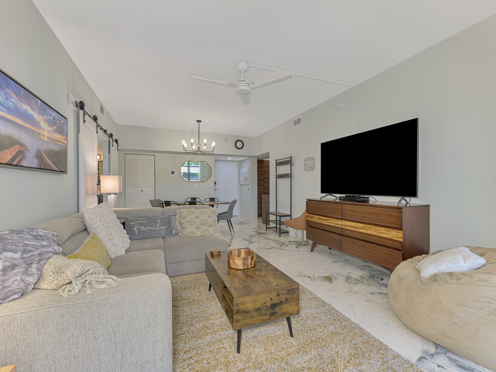 Settle into your spacious living room with plush sectional seating, large smart TV, and stylish mid-century furnishings perfect for relaxing after exploring.