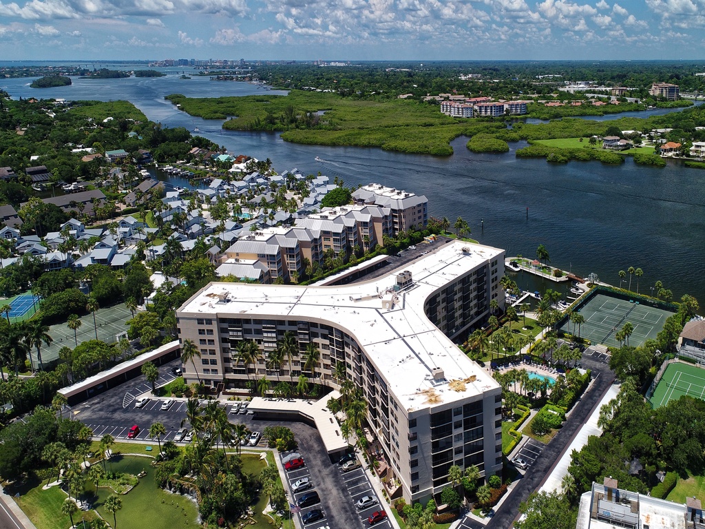 Waterfront resort property situated along scenic coastline with tennis courts, swimming pool, and abundant natural surroundings.