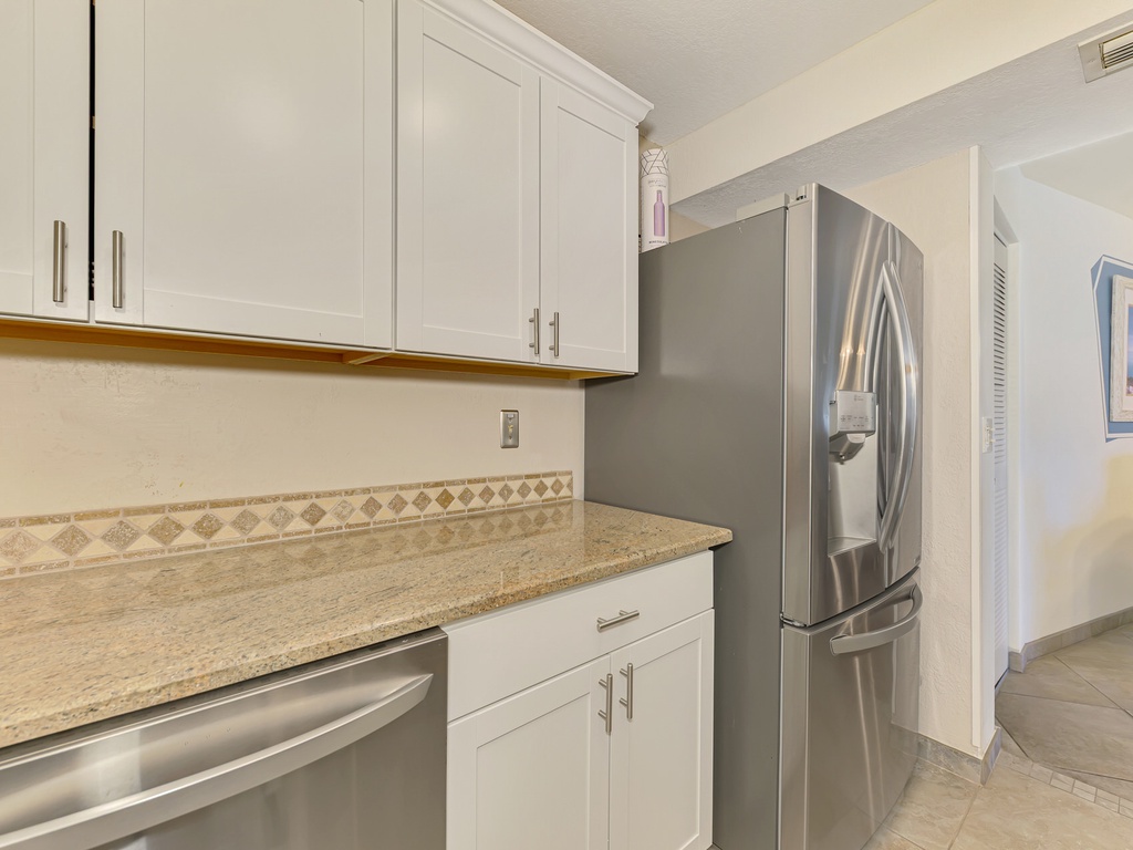 Your fully equipped kitchen features granite counters, stainless appliances, and crisp white cabinetry for effortless meal preparation.