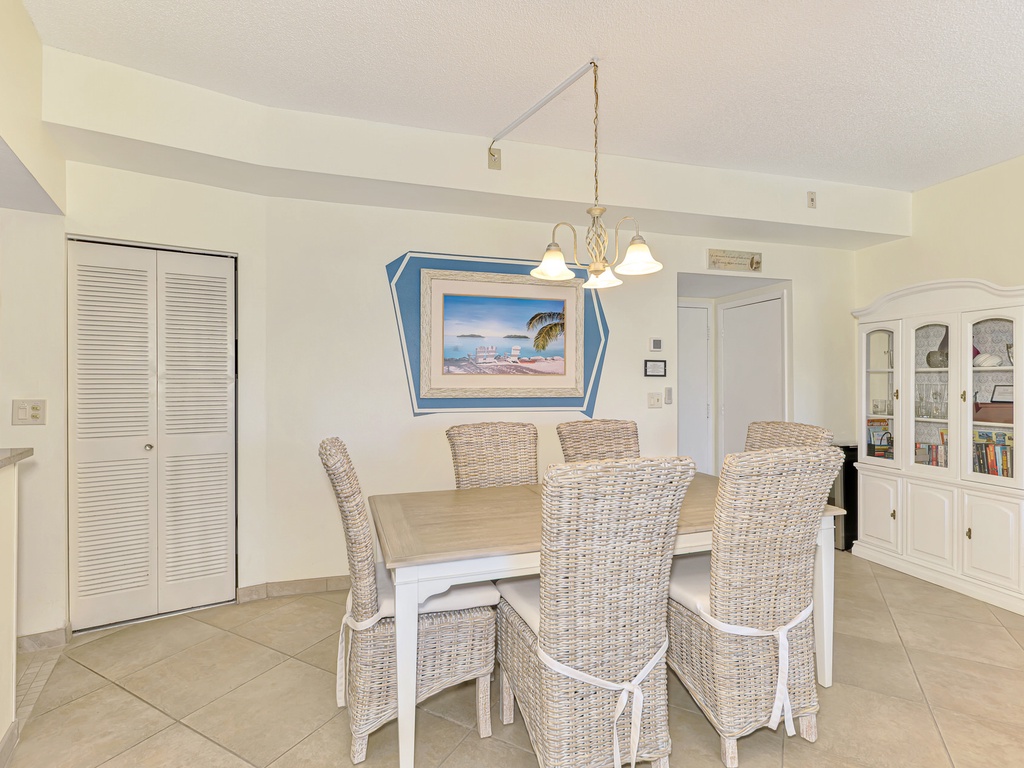 Your bright dining space features coastal charm with wicker chairs and tropical artwork, perfect for memorable meals together.