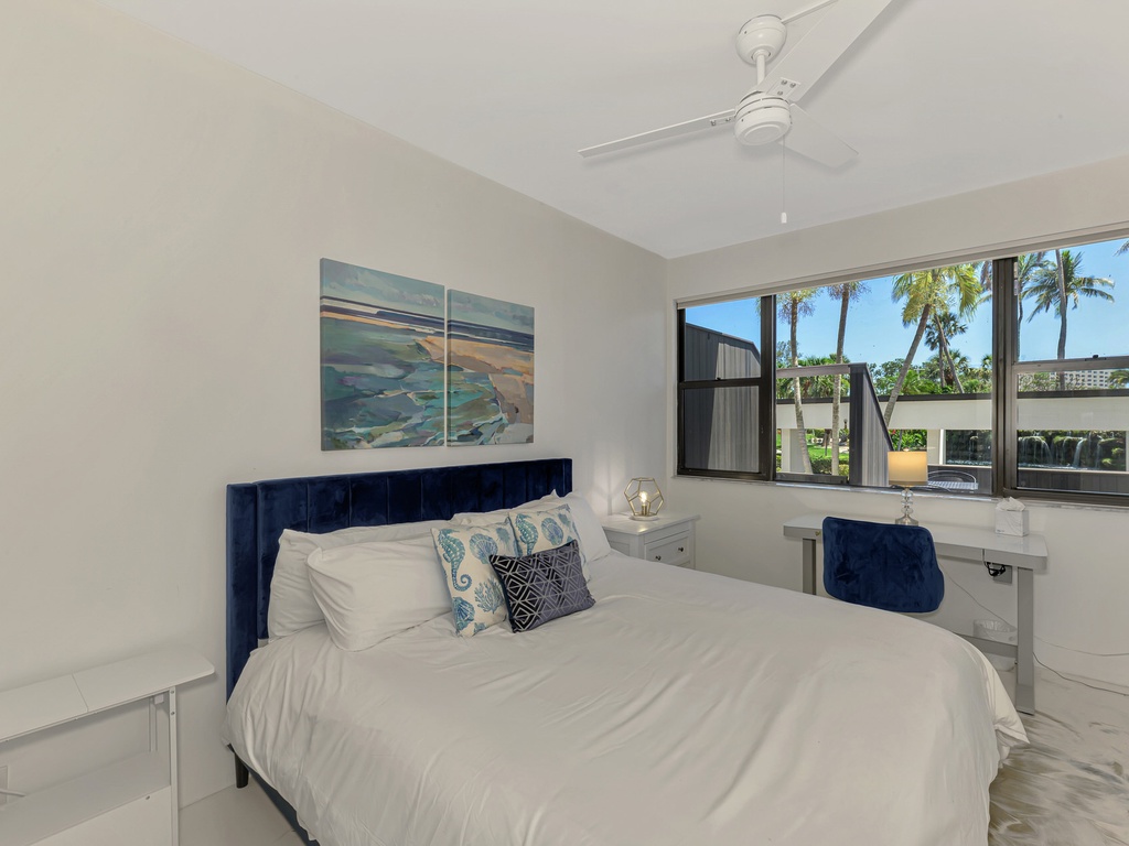 Drift off in your serene bedroom with tropical palm views and ocean-inspired art creating the perfect coastal retreat.