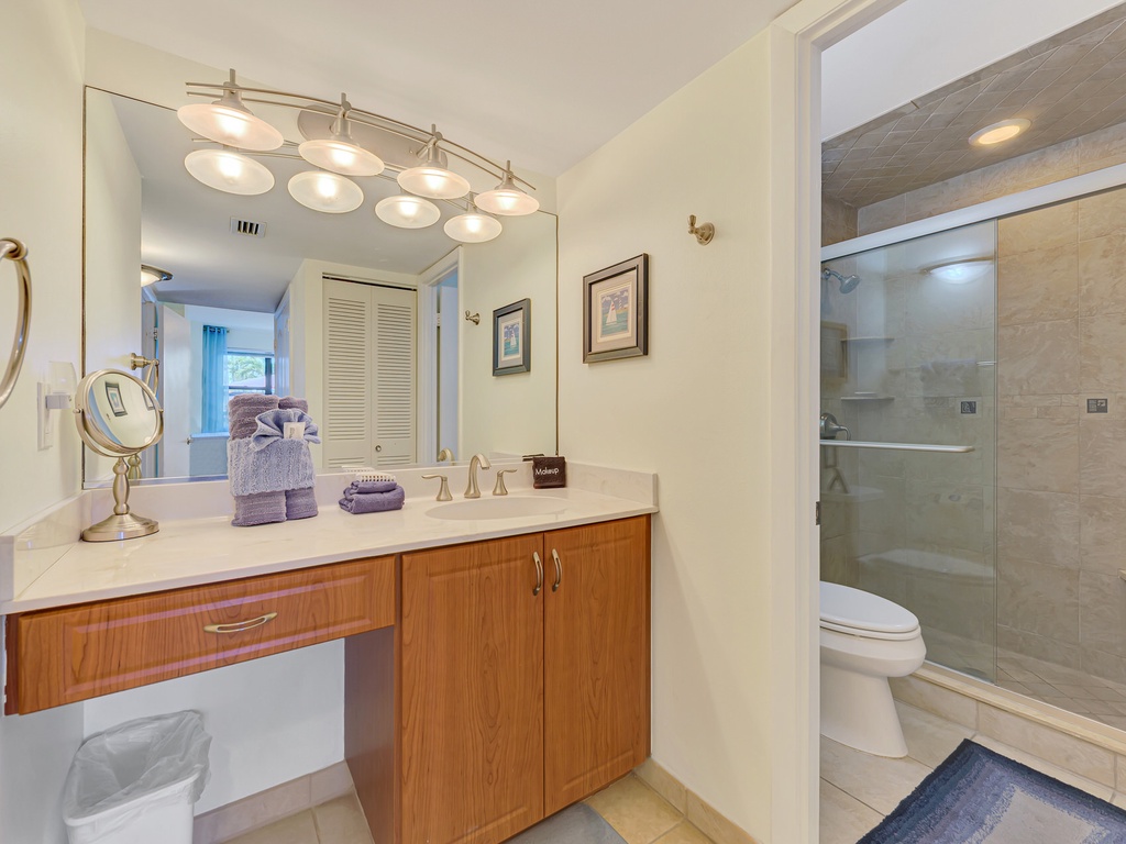 Your elegant ensuite features premium finishes, perfect vanity lighting for your morning routine, and a luxurious glass-enclosed shower.