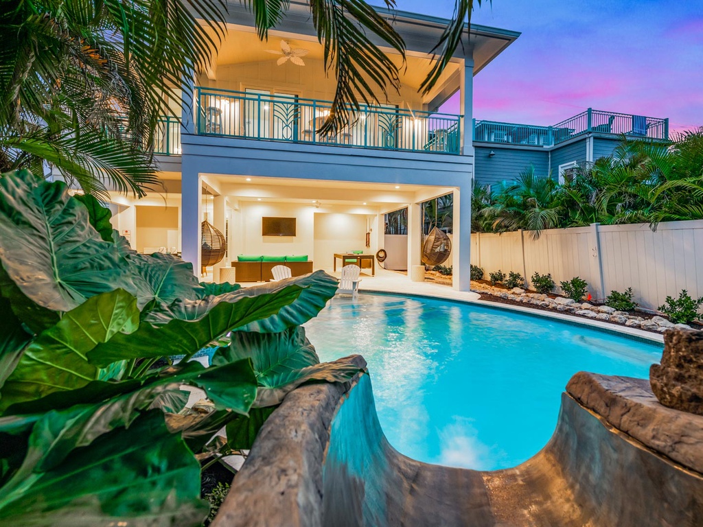 Beautiful home with a pool and waterslide at sunset