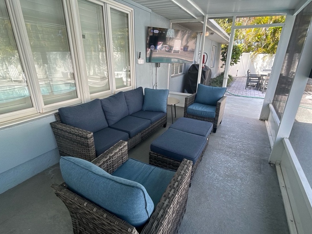 Relax in your private screened patio where comfortable seating awaits you to unwind while overlooking the pool and lush surroundings.
