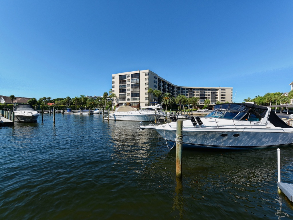 Waterfront property located on a peaceful marina with boats and tropical surroundings in a resort-style community.