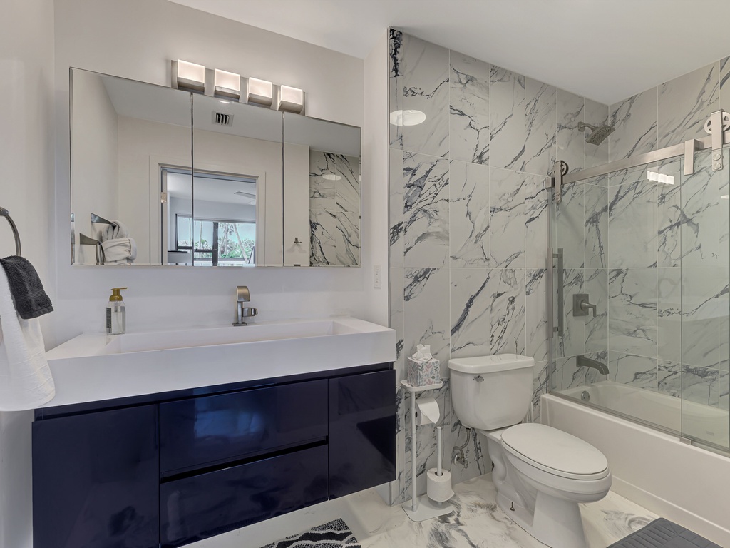 Indulge in your luxurious marble-wrapped bathroom, where elegant veining creates a spa-like retreat for your morning and evening routines.