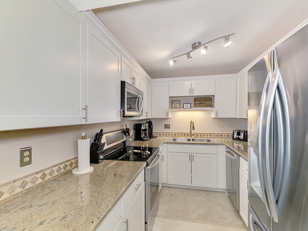 Your fully equipped kitchen features granite countertops, stainless steel appliances, and crisp white cabinetry for all your culinary adventures.