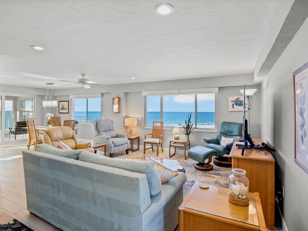 Unwind in your spacious oceanfront living room where floor-to-ceiling windows frame endless blue views and comfortable seating invites you to relax.