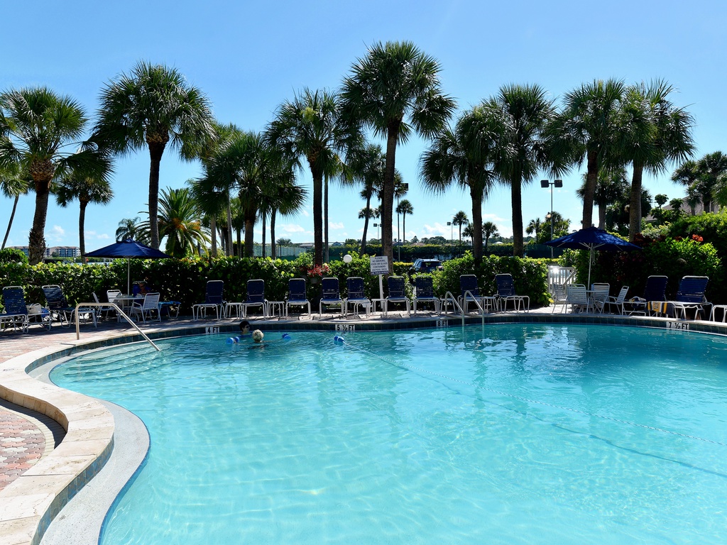 Sparkling pool surrounded by swaying palms creates your perfect tropical oasis for endless sunny afternoons.