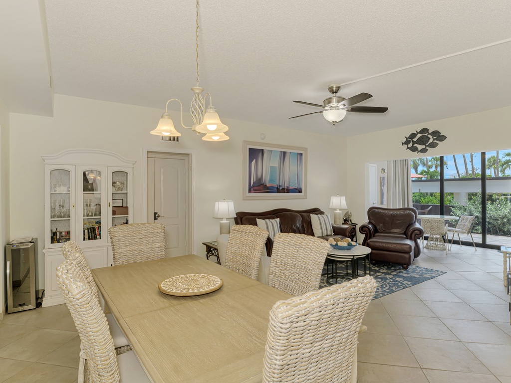 Step into your bright, open-concept living space where coastal charm meets comfort with wicker dining chairs and leather seating.
