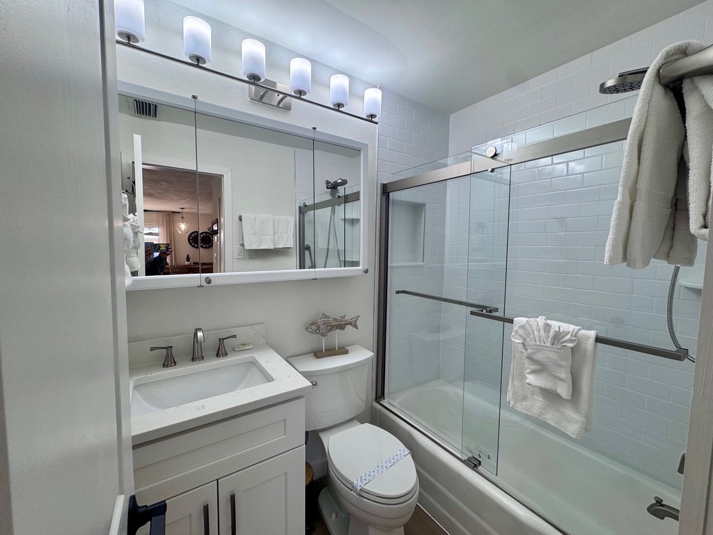 Refresh in your sparkling clean bathroom with modern fixtures, vanity lighting, and glass shower doors—plus fluffy towels ready for you.