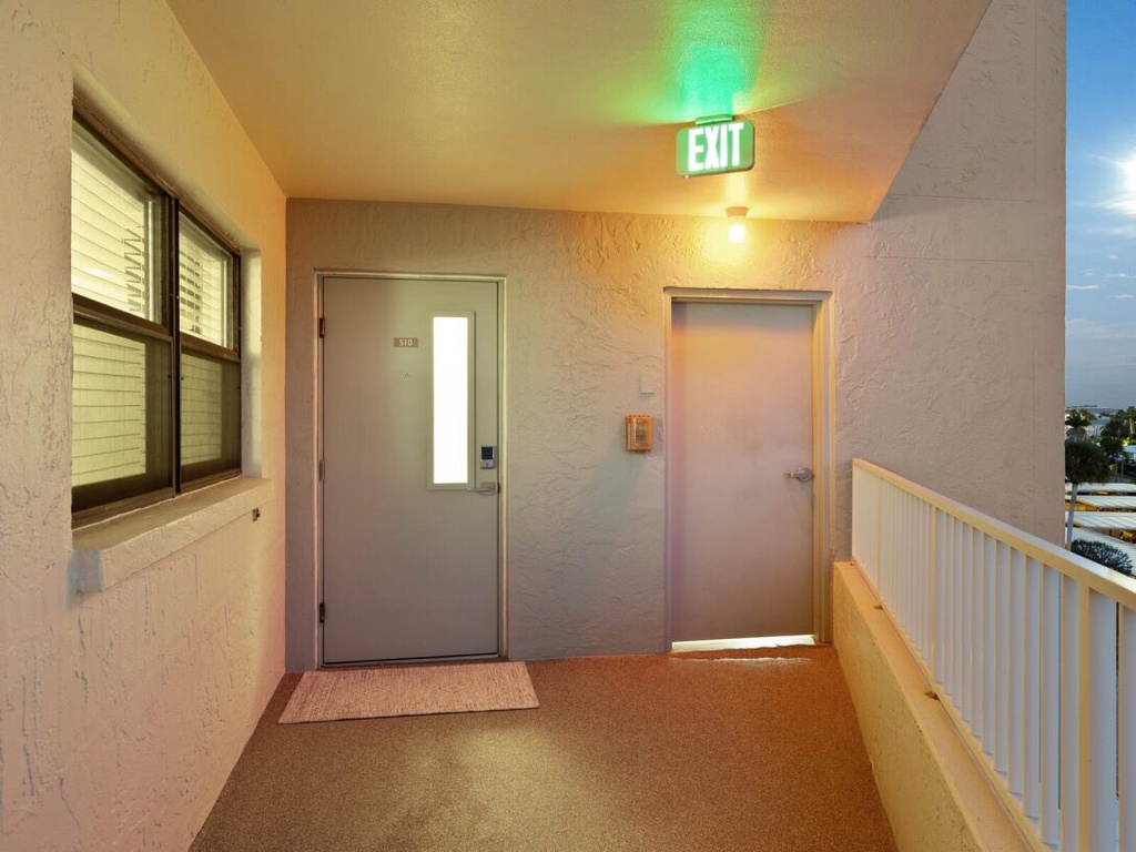 Your private entrance awaits with a welcoming covered hallway featuring warm lighting and easy stair-free access to your door.
