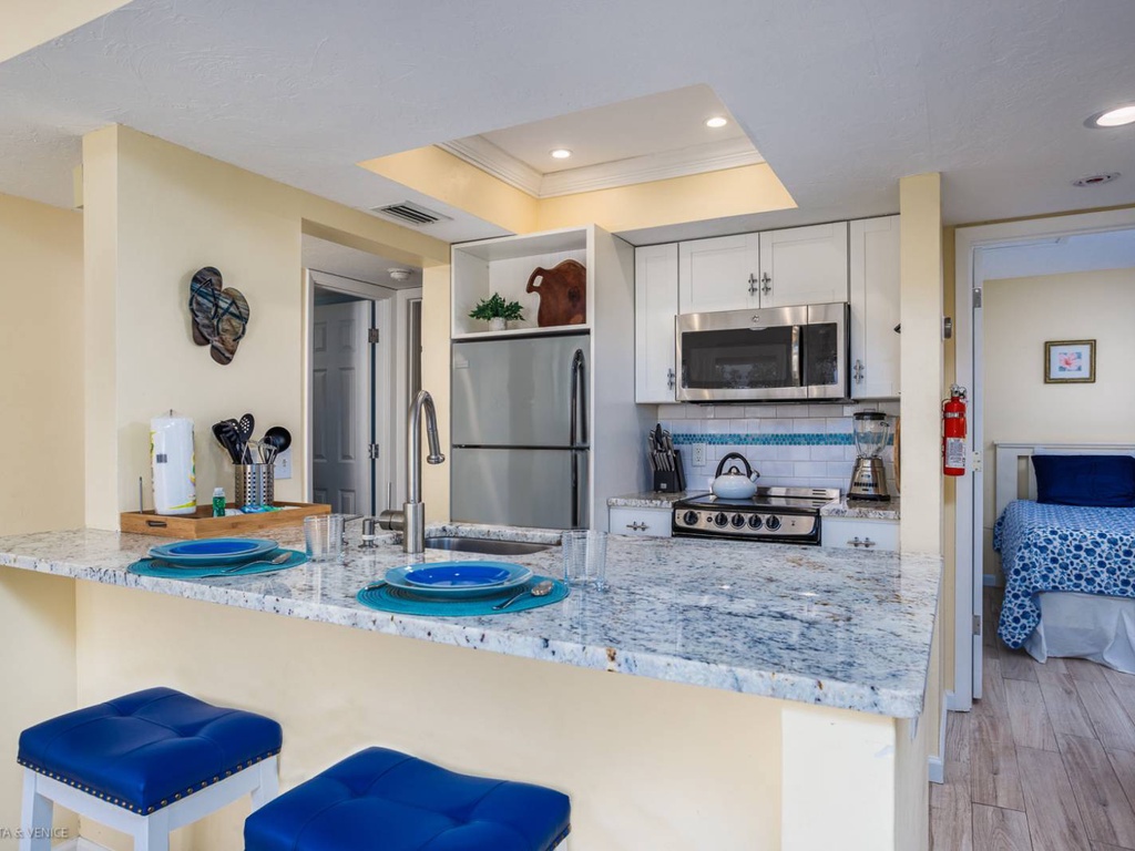 Your fully equipped kitchen features granite counters, stainless appliances, and cheerful blue accents for comfortable meal prep.