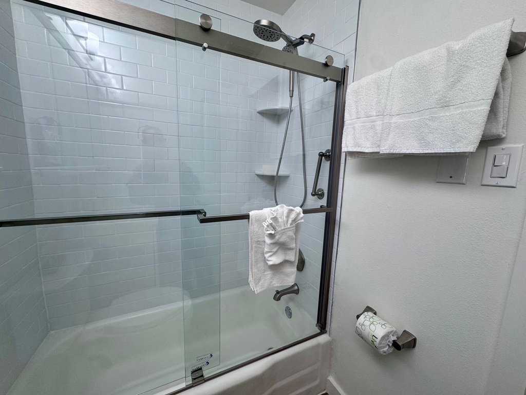 Step into your modern bathroom where fresh towels await and a spacious shower beckons for a refreshing start to your day.