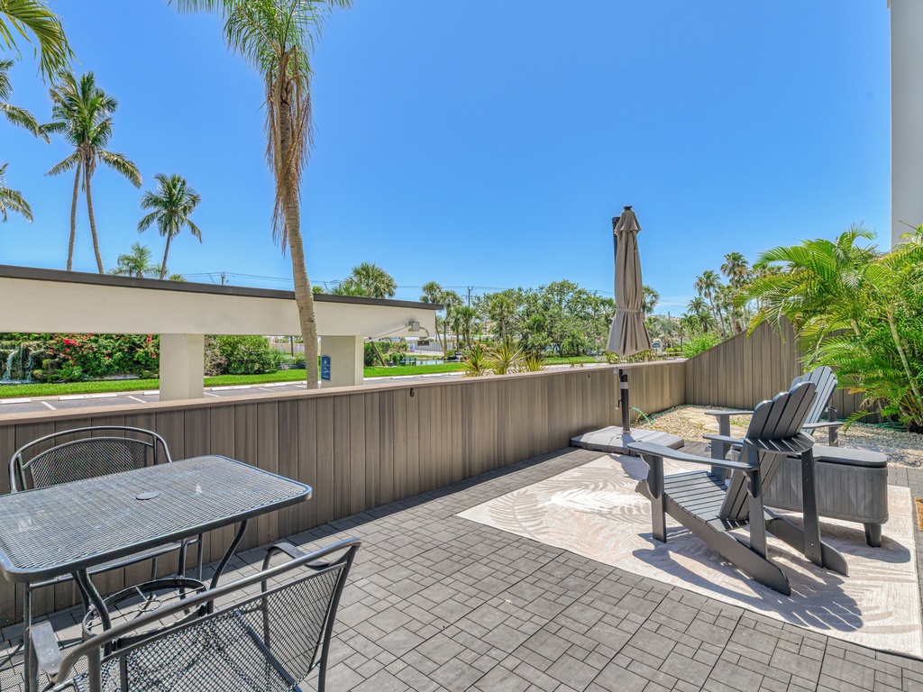 Your private patio offers comfortable outdoor dining and lounging with tropical palm views under sunny Florida skies.