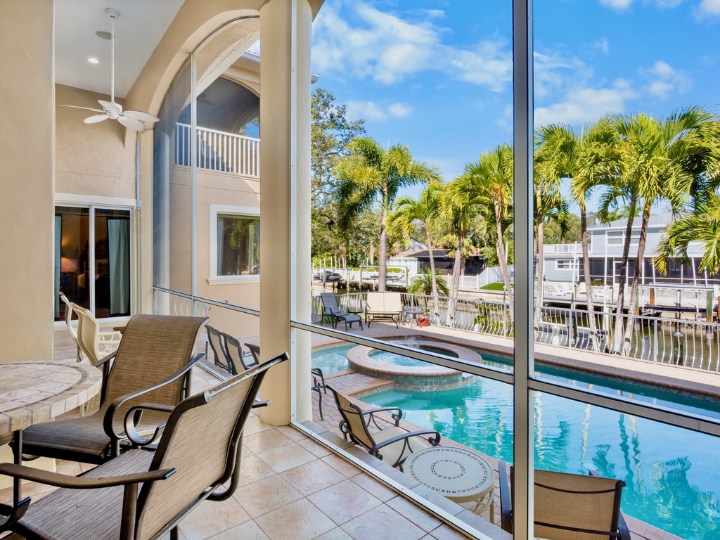 Screened-in lanai with dining area overlooking the pool