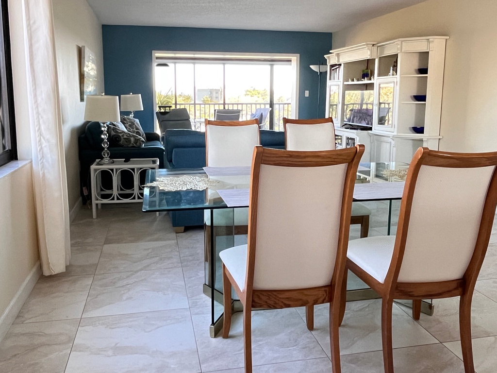 Your spacious living area flows seamlessly into the dining space, where you'll enjoy meals around the glass table while natural light pours in.