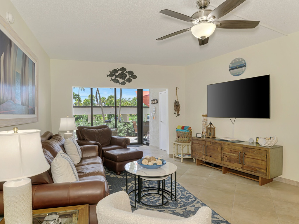 Unwind in your bright, airy living room with plush leather seating and tropical garden views through your sliding glass doors.