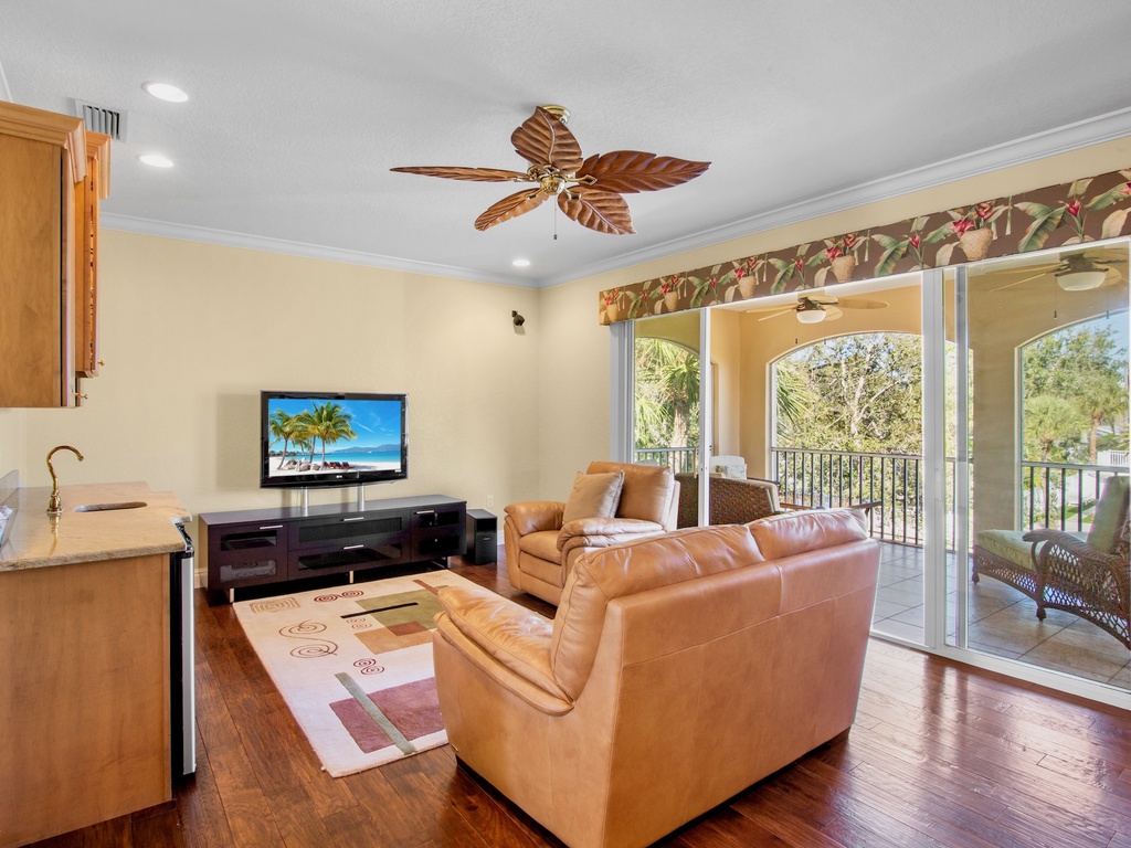 Second living room with plush seating, balcony, and TV