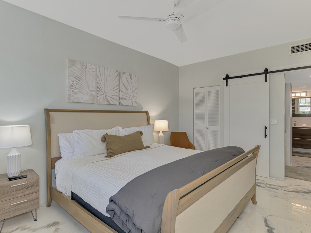 Sink into crisp linens and plush pillows in your serene bedroom sanctuary, featuring modern coastal touches and an ensuite behind sliding barn doors.