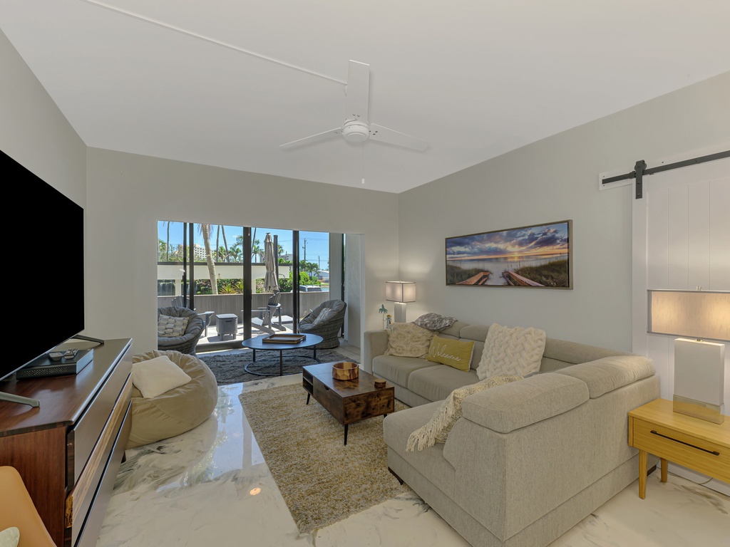 Relax in your bright living room with cozy seating, modern fireplace, and peaceful patio views.
