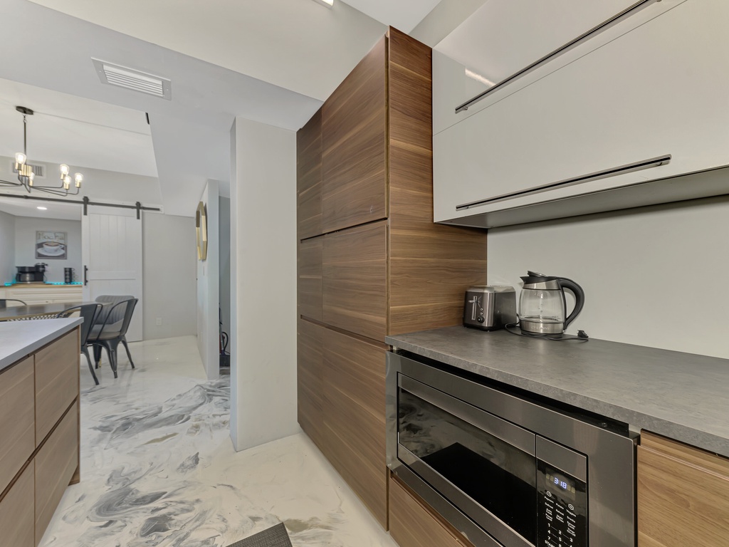 You'll love preparing meals in this sleek modern kitchen with stunning wood cabinets, granite counters, and premium appliances for your perfect getaway.