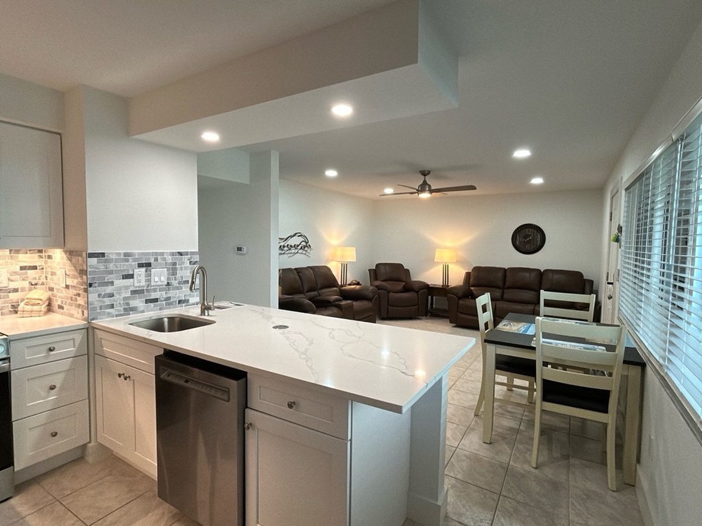 Relax in your modern kitchen featuring gleaming countertops and stainless appliances, while cozy living room seating awaits for evening conversations.