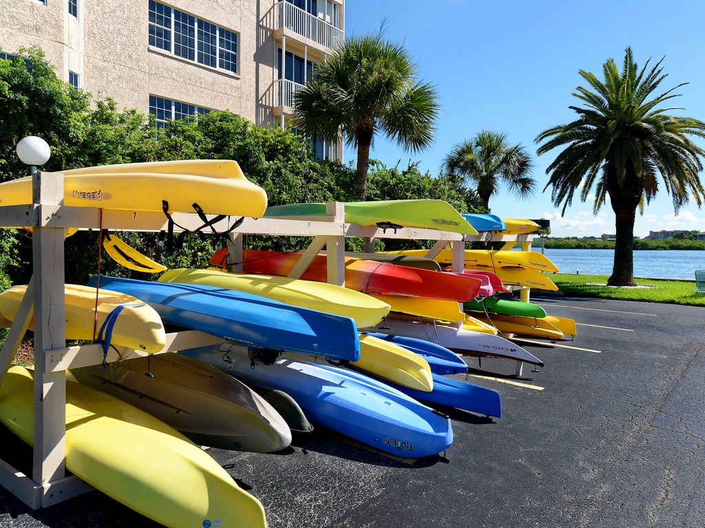 Colorful kayaks await your waterfront adventure, with tropical palms and scenic lake views creating the perfect vacation backdrop.